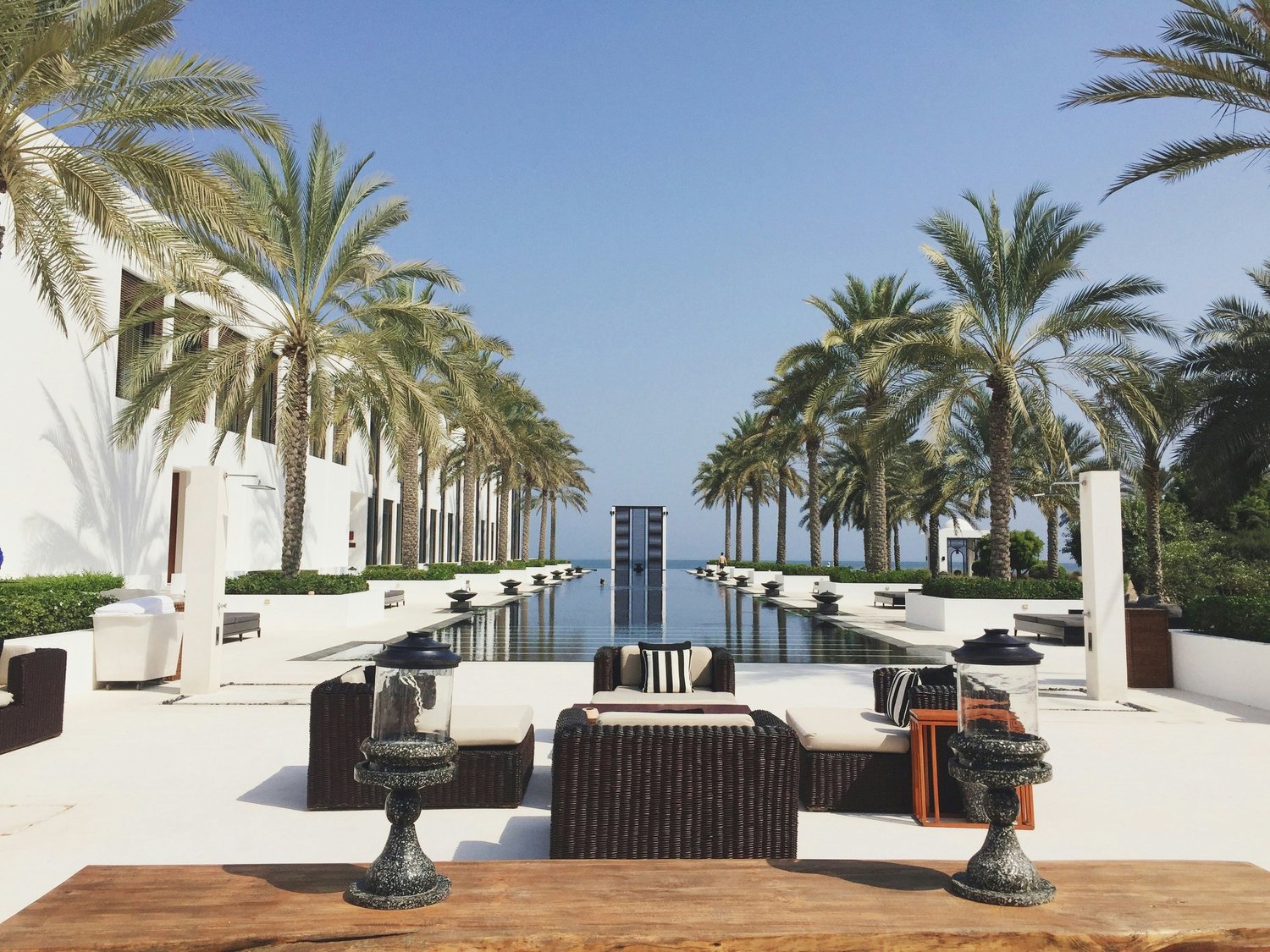 Palm-lined pool opening toward the sea