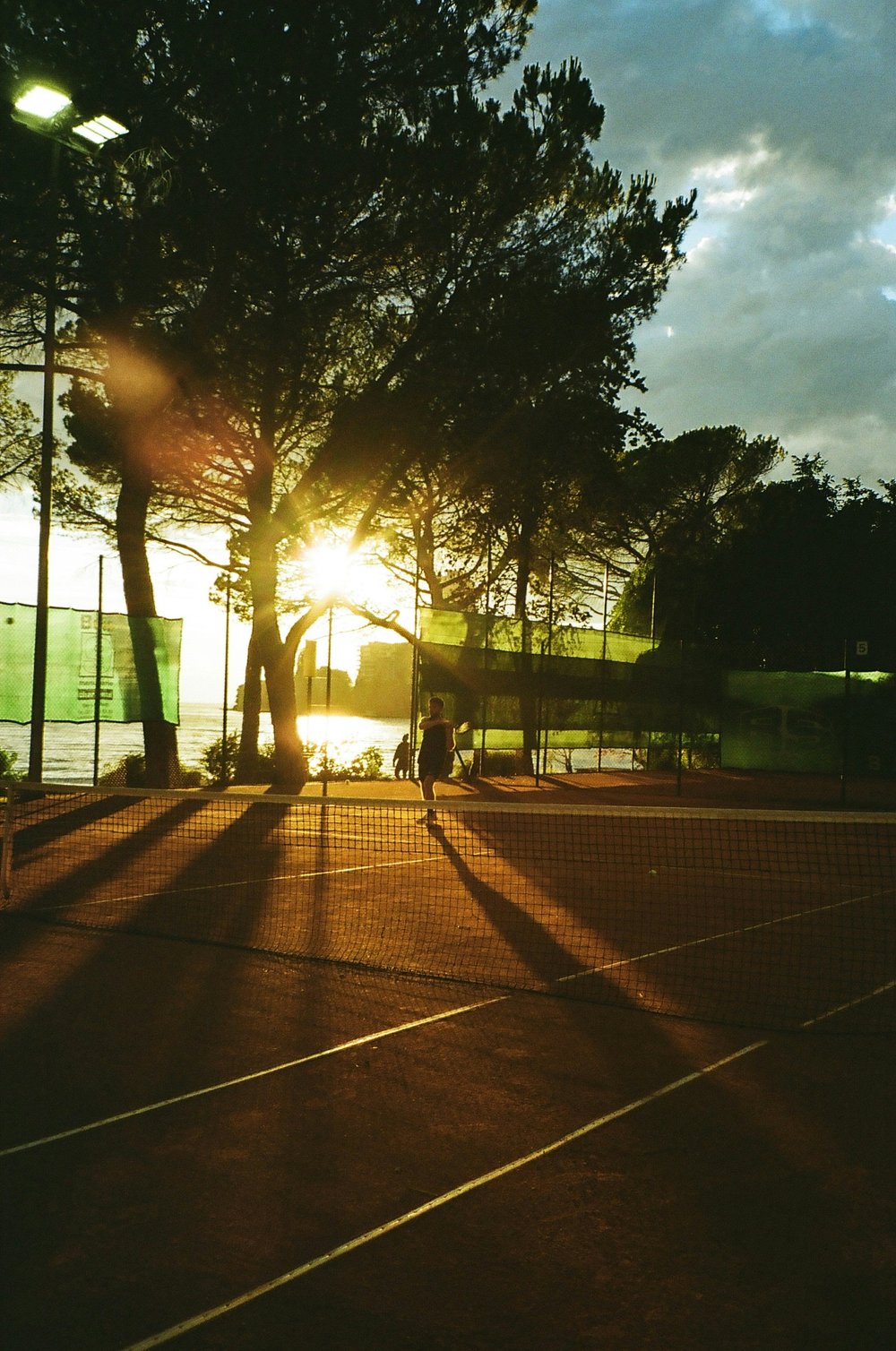 Movement outdoors on a sunlit tennis court